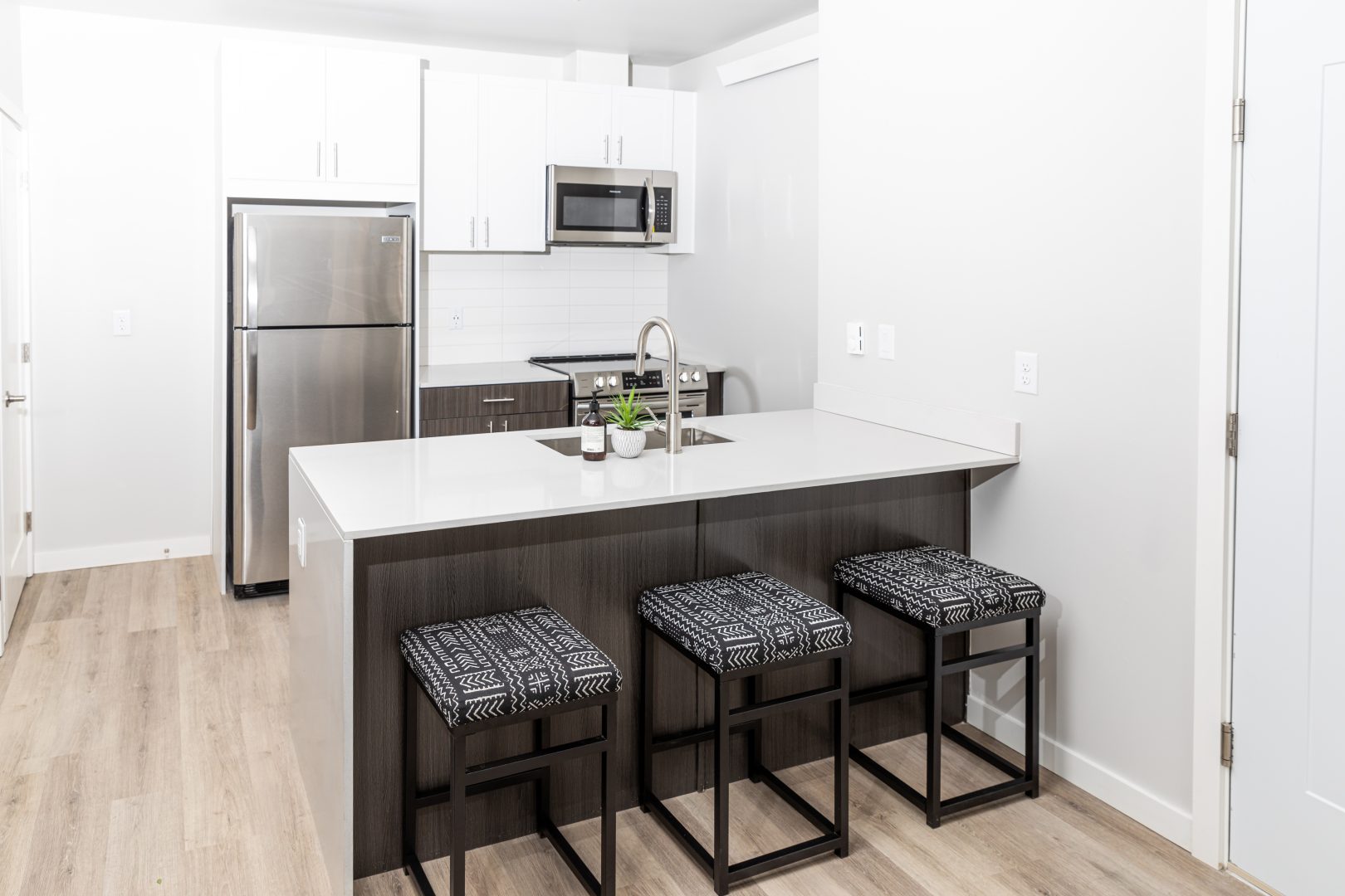 a kitchen with a stainless steel sink and bar stools at The Bighorn Crossing