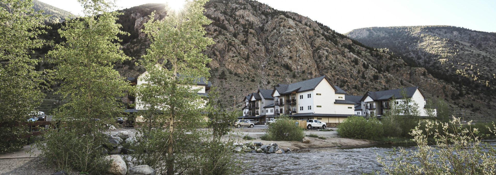 a river runs through a mountain town with houses at The Bighorn Crossing