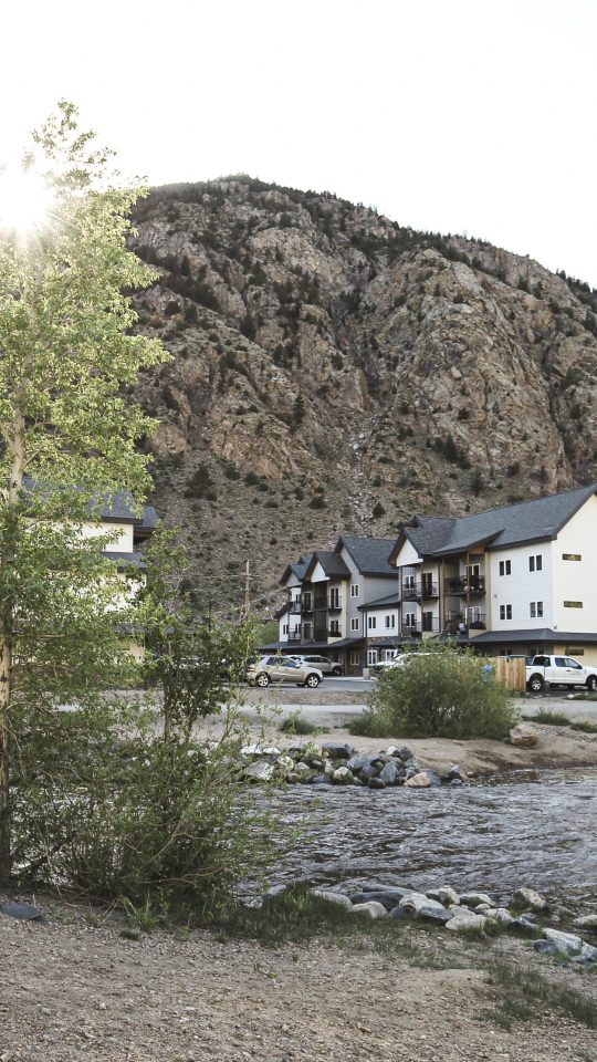 a river runs through a mountain town with houses at The Bighorn Crossing