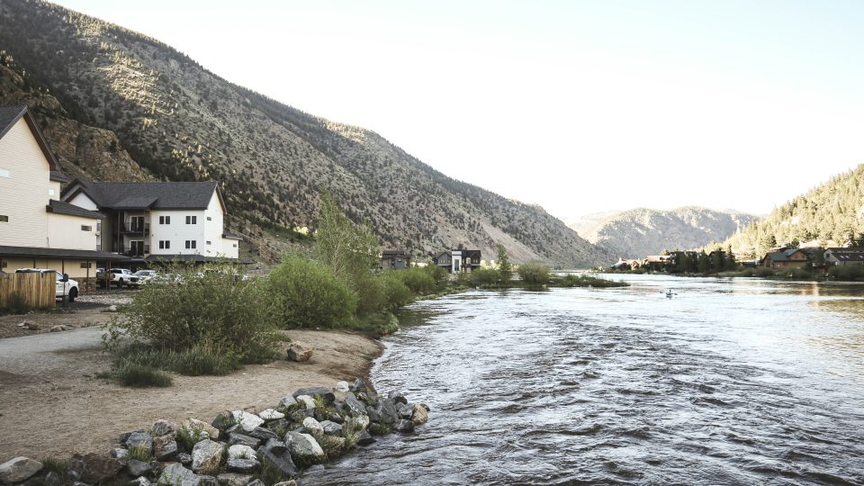 a river runs through a valley with houses on the side at The Bighorn Crossing